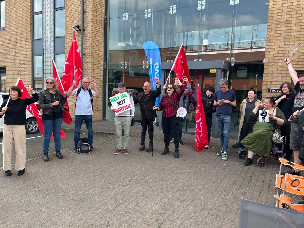 Image shows a group of people protesting outside the NICVA headquarters
