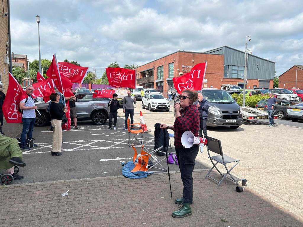 Image shows a person protesting outside the NICVA headquarters
