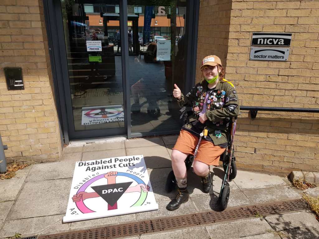 Image shows a person protesting outside the NICVA headquarters
