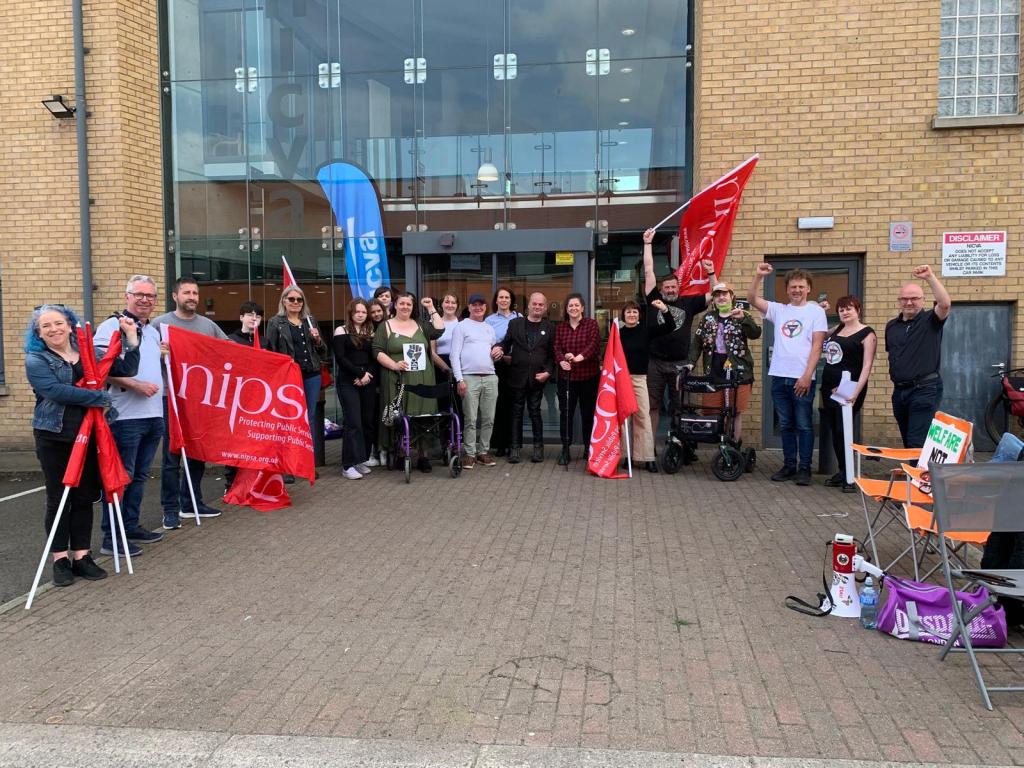 Image shows a group of people protesting outside the NICVA headquarters